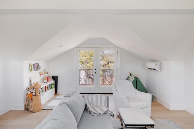 interior space featuring french doors, light hardwood / wood-style flooring, lofted ceiling, and a wall unit AC