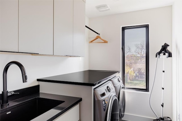 laundry area featuring washer and dryer, sink, and cabinets