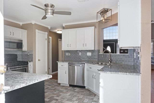 kitchen featuring light stone counters, decorative backsplash, white cabinetry, appliances with stainless steel finishes, and sink