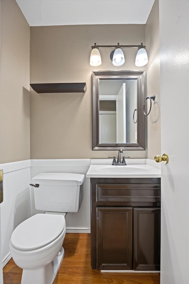 bathroom featuring toilet, wood-type flooring, and vanity