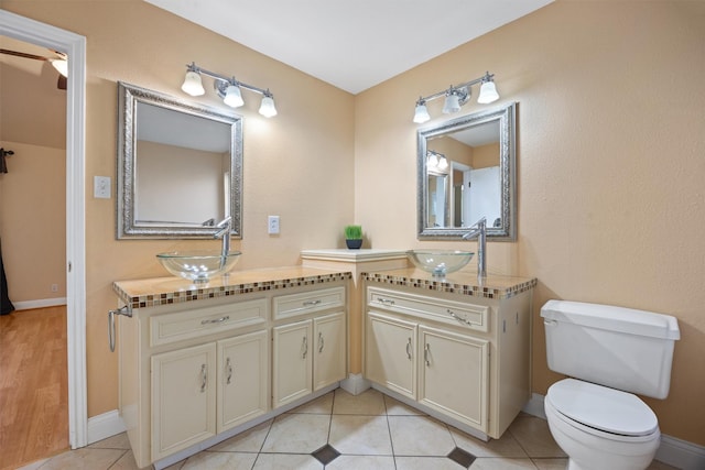 bathroom with toilet, ceiling fan, tile patterned floors, and vanity