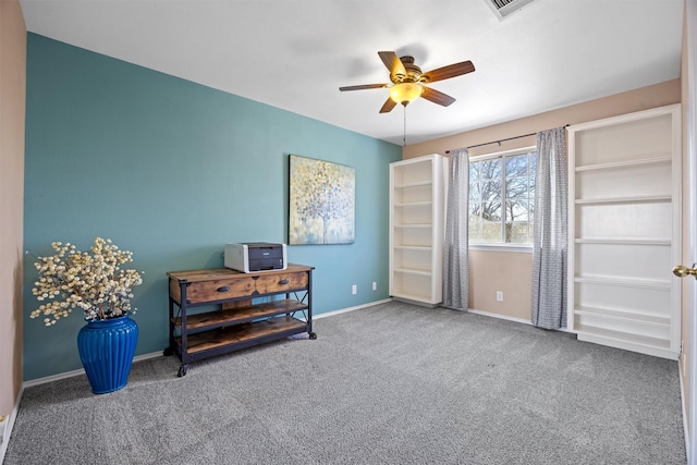 living area featuring ceiling fan and carpet