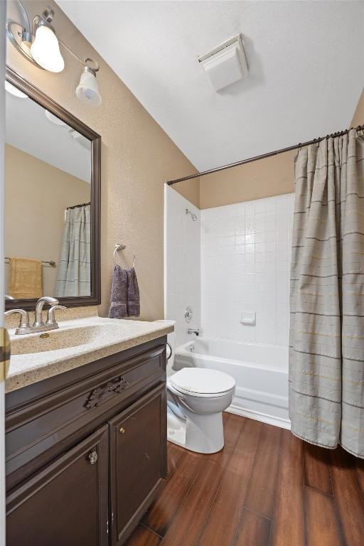 full bath featuring vanity, shower / bathtub combination with curtain, toilet, and wood finished floors