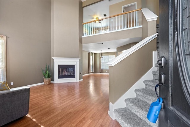 interior space featuring a towering ceiling and hardwood / wood-style flooring