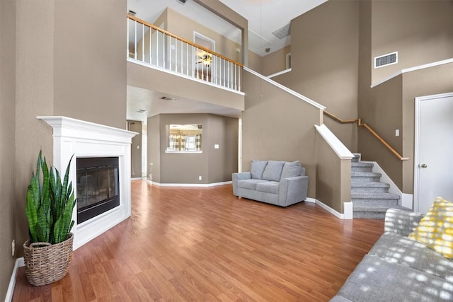 living room with a high ceiling and wood-type flooring