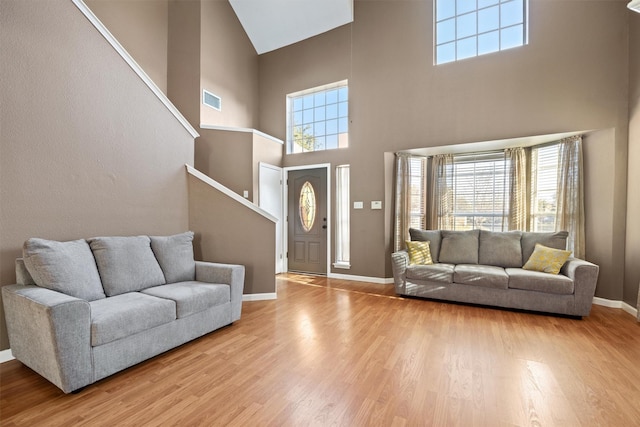 living room featuring a high ceiling and light hardwood / wood-style floors