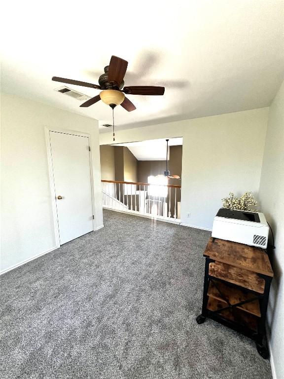 carpeted living area featuring visible vents and ceiling fan