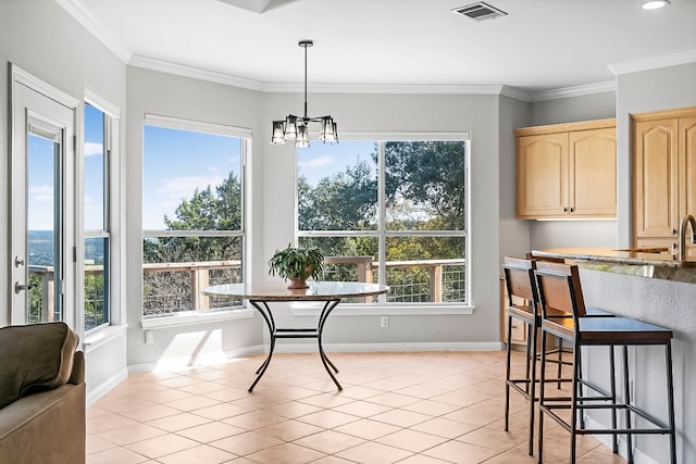 dining room with baseboards, light tile patterned flooring, visible vents, and crown molding