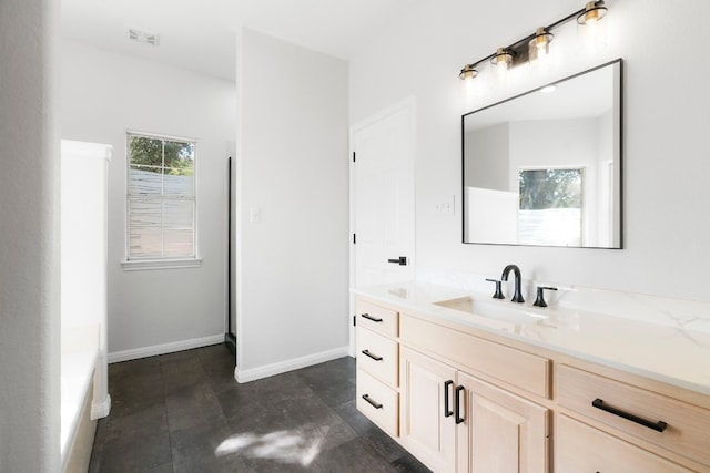 bathroom with visible vents, vanity, and baseboards