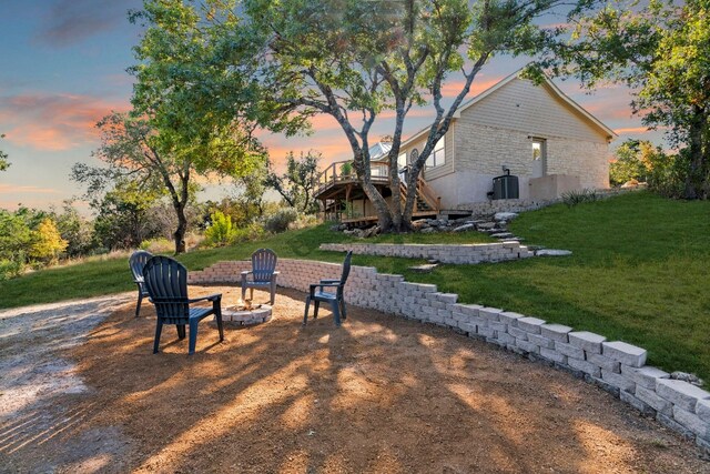 yard at dusk featuring an outdoor fire pit and a wooden deck