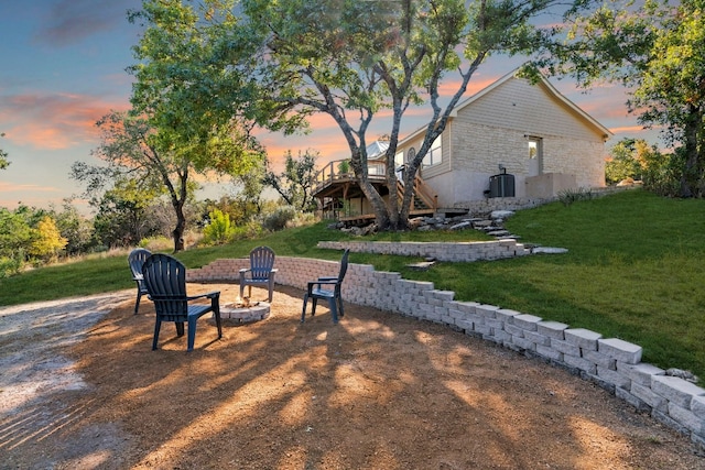 view of yard with an outdoor fire pit, a wooden deck, and stairs