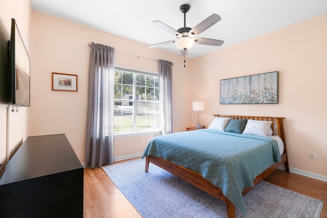 bedroom featuring ceiling fan, light wood-type flooring, and baseboards