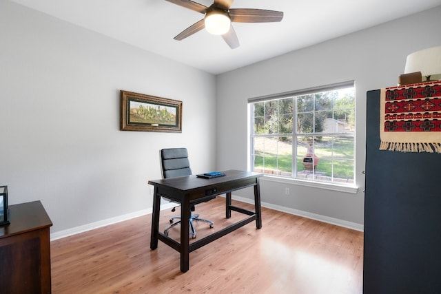 home office with light wood finished floors, ceiling fan, and baseboards