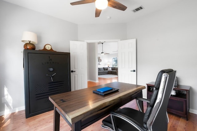 home office with ceiling fan, baseboards, visible vents, and light wood-style floors