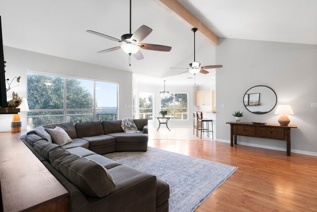 living room featuring baseboards, a ceiling fan, light wood-style flooring, high vaulted ceiling, and beam ceiling