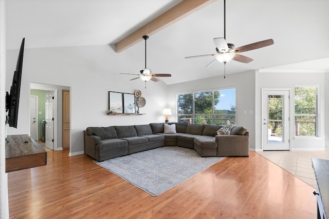 living room with light wood-type flooring, beam ceiling, and baseboards