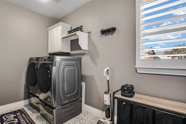 washroom with cabinets and washer and dryer