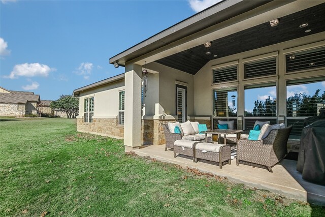 rear view of property with a lawn, an outdoor living space, and a patio area