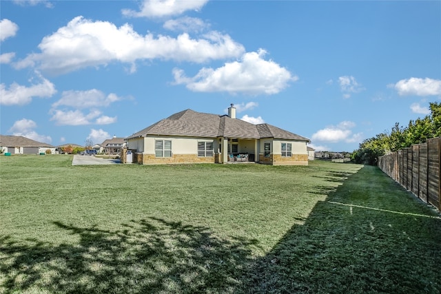 rear view of property with a lawn