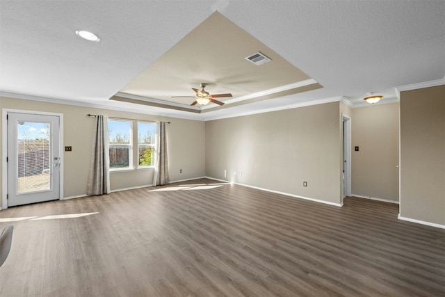 empty room with dark wood-type flooring, a raised ceiling, ceiling fan, and ornamental molding