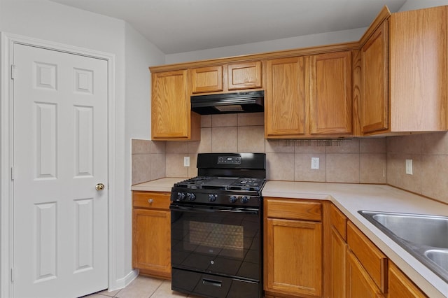 kitchen featuring decorative backsplash, light tile patterned flooring, range hood, black range with gas stovetop, and sink