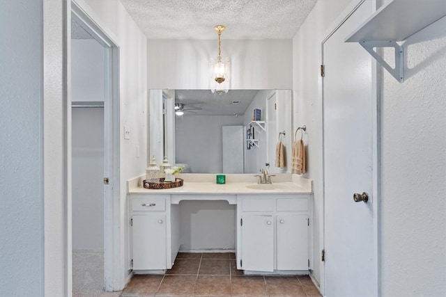 bathroom with tile patterned floors, ceiling fan, a textured ceiling, and vanity