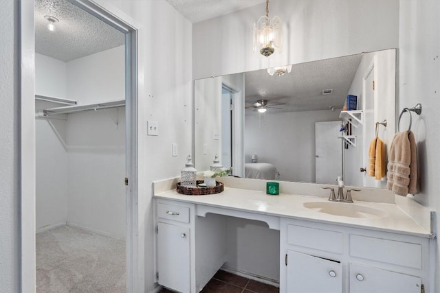 bathroom featuring ceiling fan, a textured ceiling, and vanity