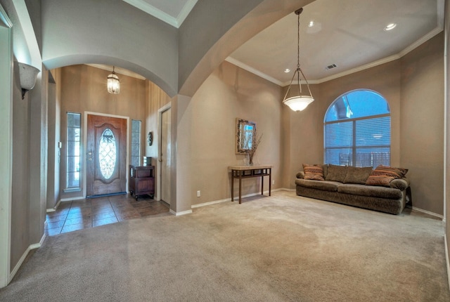 entrance foyer featuring carpet, crown molding, a high ceiling, and a chandelier