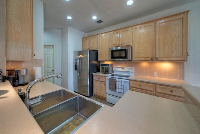 kitchen featuring appliances with stainless steel finishes, tasteful backsplash, light brown cabinetry, and sink