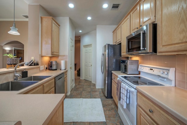 kitchen featuring appliances with stainless steel finishes, light brown cabinetry, pendant lighting, and sink