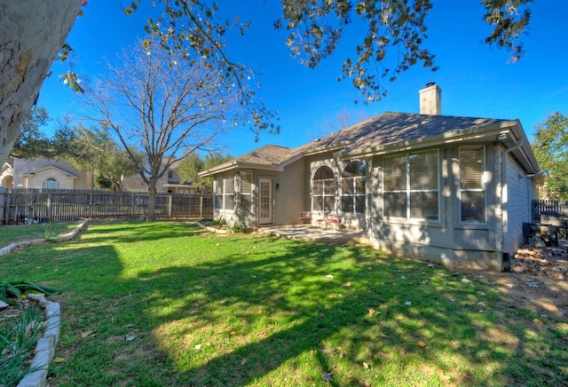 rear view of house with a lawn, a sunroom, and a patio