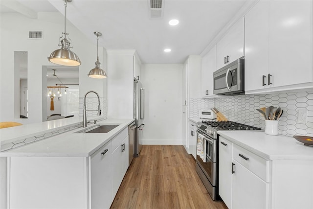 kitchen featuring sink, decorative backsplash, decorative light fixtures, white cabinetry, and stainless steel appliances