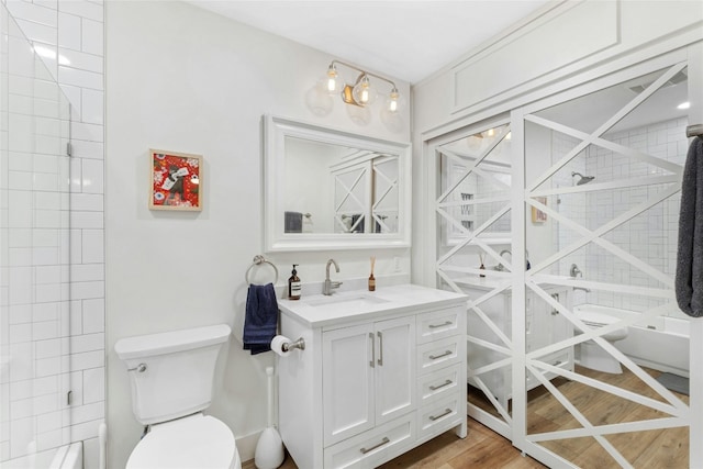 bathroom featuring a shower, wood-type flooring, vanity, and toilet