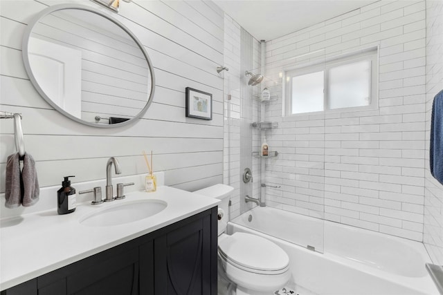 full bathroom with vanity, wood walls, toilet, and enclosed tub / shower combo