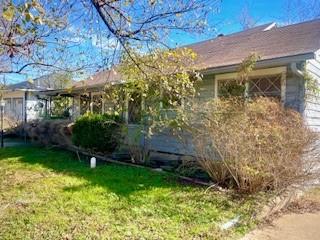 view of side of home with a yard