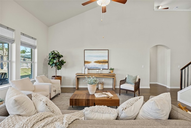 living room with dark hardwood / wood-style floors, high vaulted ceiling, and ceiling fan