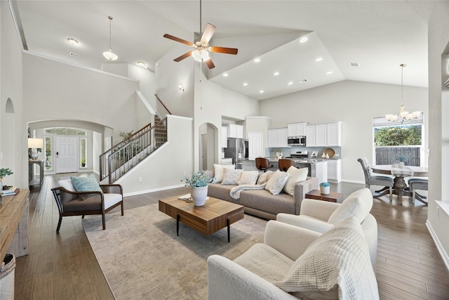 living room featuring hardwood / wood-style floors, ceiling fan with notable chandelier, and high vaulted ceiling