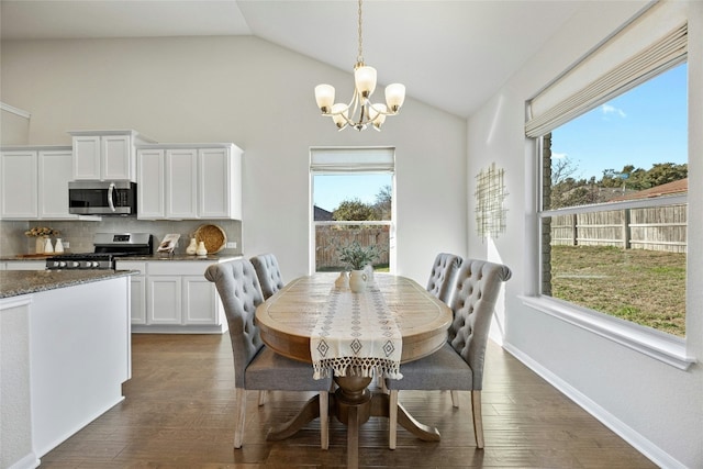 dining space featuring a healthy amount of sunlight, lofted ceiling, and a notable chandelier