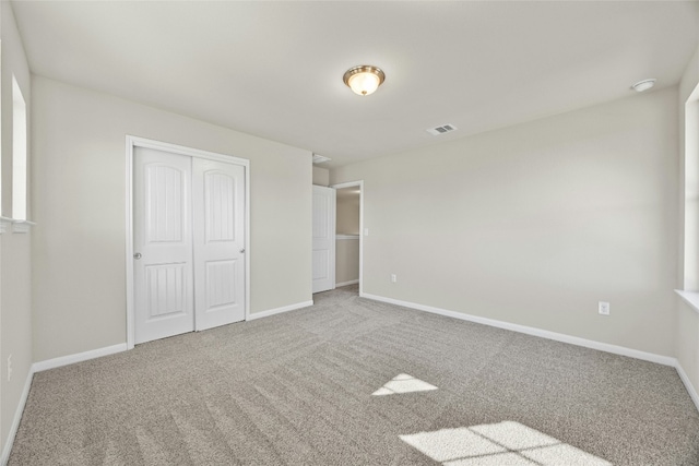 unfurnished bedroom featuring carpet flooring and a closet