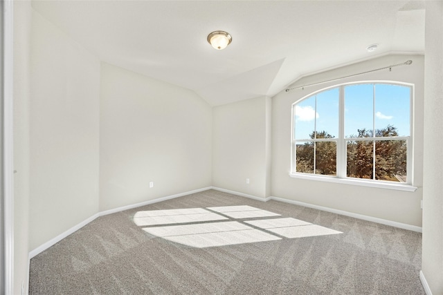 carpeted spare room featuring lofted ceiling