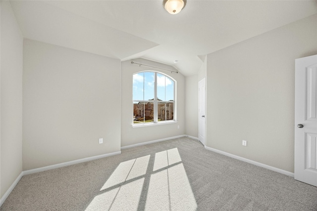 unfurnished room featuring light carpet and vaulted ceiling