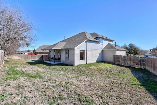 rear view of house with a lawn and a patio area