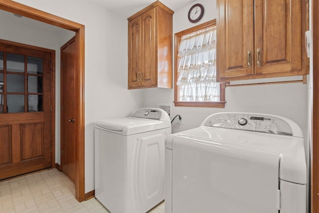 washroom with cabinets and washing machine and clothes dryer