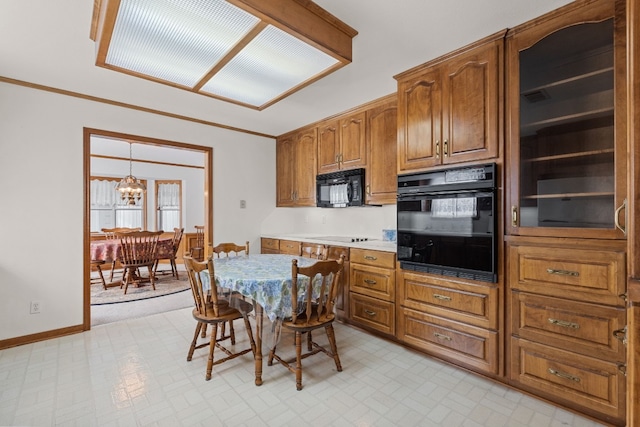 kitchen with crown molding, black appliances, and an inviting chandelier