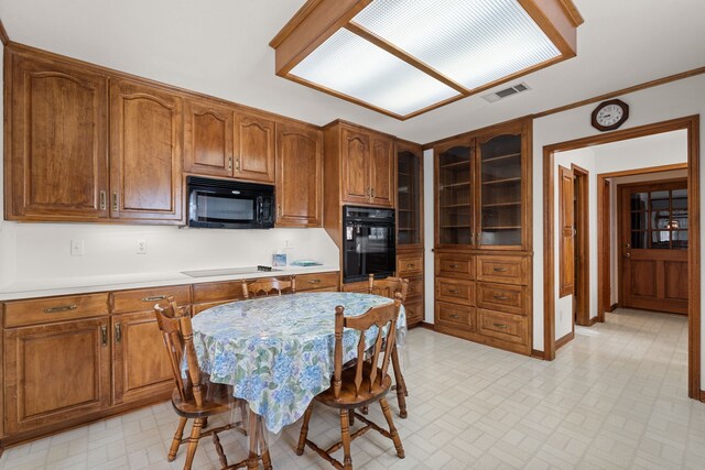 kitchen with crown molding and black appliances