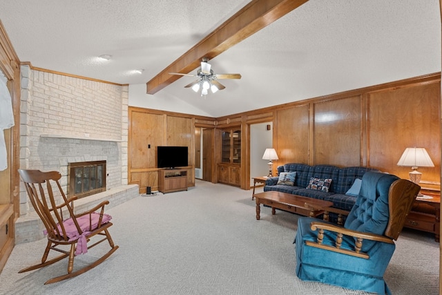 living room with light carpet, a brick fireplace, a textured ceiling, ceiling fan, and wooden walls