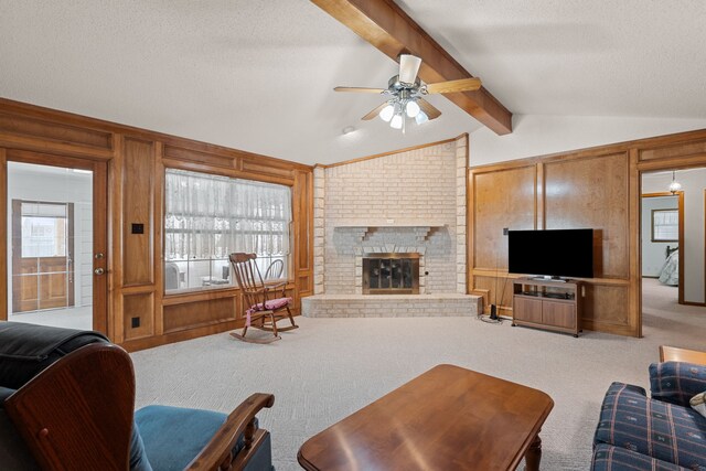 living room featuring carpet flooring, vaulted ceiling with beams, wooden walls, and a fireplace