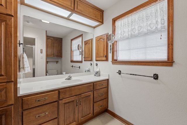 bathroom featuring vanity, an enclosed shower, and toilet