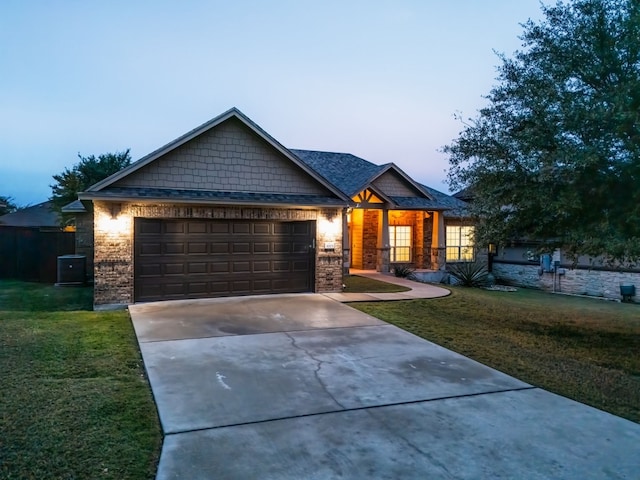 craftsman inspired home with a garage and a yard