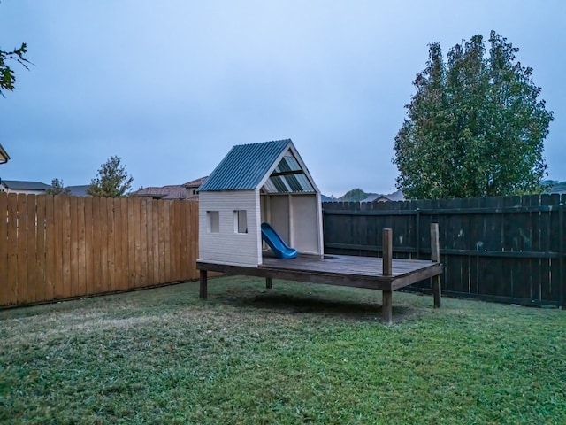 view of playground with a yard and a storage unit